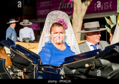 I vecchi spagnolo giovane in abito tradizionale, donne che indossano peineta, seduta in carrozzella, Fuengirola, Malaga, Spagna. Foto Stock