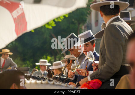 Alcuni giovani cavalieri spagnoli in un bar, bere sherry, indossando cappelli spagnolo, nel corso annuale di equitazione evento. Fuengirola, Andalusia. Foto Stock