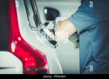 Veicoli professionali mediante lucidatura auto caucasica dettagliando lavoratore di servizio. Rimuovere graffi dalla carrozzeria di auto Paint. Lucidatura auto. Foto Stock