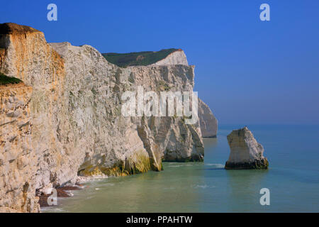 Bella bianco chalk cliff pila Seaford East Sussex England Regno Unito vicino a sette sorelle con onde che lambiscono le scogliere e il blu del mare e del cielo Foto Stock