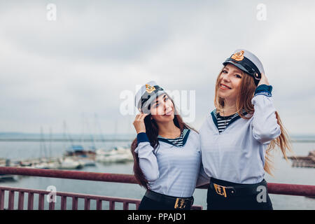 Due college studenti donne di Marine Academy a piedi dal mare indossando uniforme. Amici di Felice costeggiata dal porto di Odessa Foto Stock