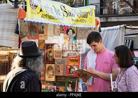 Due clienti in cerca di un libro in una gabbia di San Telmo antichità fiera. Buenos Aires, Argentina. Foto Stock