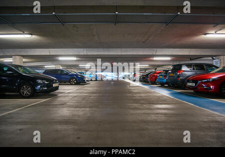 La metropolitana multipiano parcheggio / garage con auto parcheggiate su entrambi i lati. Foto Stock