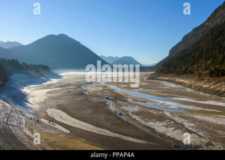 Sgonfiato lago di storage con i turisti in inverno Lago Sylvenstein, Isartal, Lenggries, Alta Baviera, Baviera, Germania, Europa Foto Stock