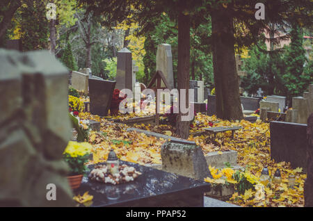 Decorate tombe nel cimitero durante il giorno di Tutti i Santi nel periodo autunnale Foto Stock