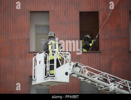 Italia, IT, Italia - 10 Maggio 2018: Italiano vigile del fuoco sulla piattaforma aerea presso la stazione dei vigili del fuoco con una uniforme e testo Vigili del Fuoco significa che i Vigili del Fuoco Foto Stock