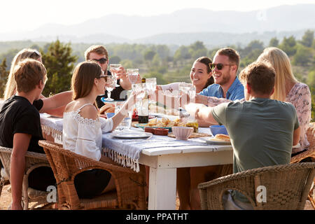 Un gruppo di giovani amici gustando pasti all'aperto in vacanza Foto Stock