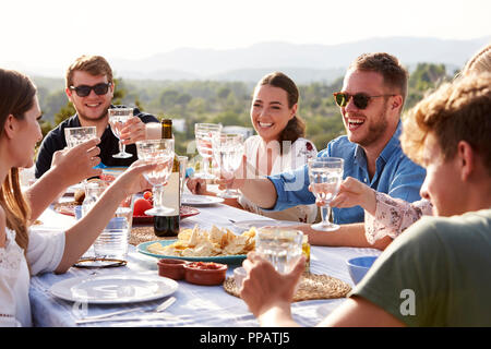 Un gruppo di giovani amici gustando pasti all'aperto in vacanza Foto Stock