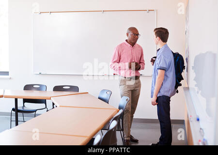 Alta scuola Tutor parlando con maschio studente dopo la classe Foto Stock