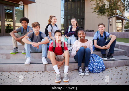 Ritratto di alta scuola gruppo di studenti seduti al di fuori del College di edifici Foto Stock