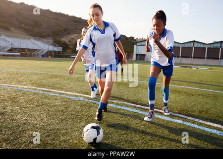 Gruppo di tre calciatori femminili allo stadio. Una squadra di calcio  femminile con una palla che esce dallo stadio dopo una sessione di  allenamento Foto stock - Alamy