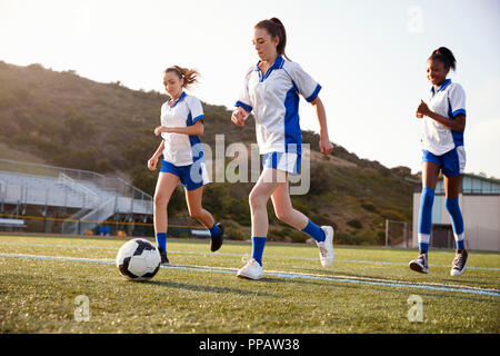 Gruppo femminile di alta scuola gli studenti giocando in squadra di calcio Foto Stock
