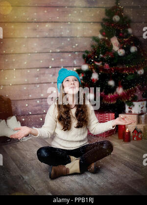 Bambina con un cappuccio a maglia su un nuovo anno di sfondo Foto Stock