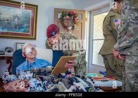 I soldati del primo battaglione, 507th Parachute reggimento di fanteria e membri del Liberty Team salto visita il Mag. (Ret.) Lubert ala a casa sua, 15 agosto 2018 in Phenix City, Alabama. Ala, 93, e un veterano della II Guerra Mondiale, Corea e Vietnam hanno combattuto nelle Ardenne durante la Battaglia di Bulge e successivamente saltò nella gamma di funzionamento. Egli ha commissionato nel 1952 e ritirato dal servizio attivo come un importante nel 1965. Il Mag. (Ret.) ala è stato un pilota di elicottero istruttore fino all'età di 75. Foto Stock