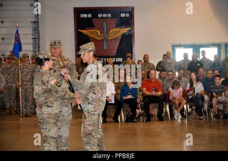 Lt. Col. Michael Girvin, comandante della 2-104th supporto generale del battaglione di aviazione, passa il non-ufficiale incaricato spada al comando Sgt. Il Mag. Shannon Cullen, comando in arrivo sergente maggiore dell'2-104th GSAB, mentre la famiglia e gli amici guardare durante un cambio di responsabilità cerimonia nella ventottesima Expeditionary combattere la Brigata Aerea armory, 19 Agosto, 2018. Cullen si assume la responsabilità come 2-104th supporto generale del battaglione di aviazione del comando del sergente maggiore dal comando Sgt. Il Mag. Jeffrey Tracey. Il passaggio del non-ufficiale incaricato spada significa la rinuncia di responsabilità Foto Stock