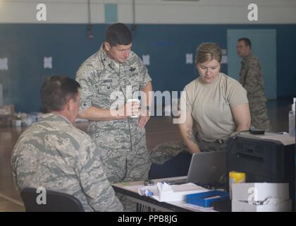 Stati Uniti Air Force Col. Henry Harder, vice comandante, 158Fighter Wing, Vermont Air National Guard, è informato dal Senior Airman Taylor Johnson, un optometria tecnico assegnato al Vermont Air National Guard, sul processo di fabbricazione durante il Tropic Care Maui County 2018 a Anthony T. Kahoohanohano Armory, Puunene, Hawaii, Aug.16, 2018. Tropic Care Maui County 2018 è una joint-servizio, "hands-on" disponibilità missione di formazione offrendo nessun costo di personale medico, dentistico e vision servizi alle persone in sei posizioni in tutta Maui Molokai e Lanai da Agosto 11-19. Foto Stock