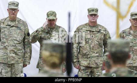 Stati Uniti Esercito Col. Patrick Sullivan, comandante del xx Engineer Brigade, saluta un soldato durante una cerimonia di premiazione che si terrà per il trasferimento delle competenze operative dall'uscita di 35th Engineer brigata per il ventesimo EB a Camp Buehring, Kuwait, Agosto 16, 2018. Il trasferimento di autorità cerimonia di premiazione si svolge a simboleggiare la conclusione di una unità della missione e l'inizio di un altro. Foto Stock