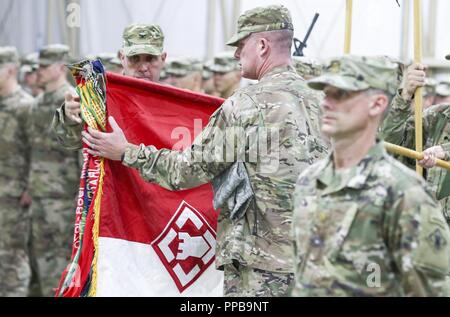 Stati Uniti Esercito Col. Patrick Sullivan, comandante del xx Engineer Brigade, E DEGLI STATI UNITI Comando Esercito Sgt. Il Mag. John Brennan, il comando sergente maggiore del XX EB, uncase loro brigata di colori a una cerimonia di premiazione che si terrà per il trasferimento delle competenze operative dall'uscita 35EB per il ventesimo EB a Camp Buehring, Kuwait, Agosto 16, 2018. Il trasferimento di autorità cerimonia di premiazione si svolge a simboleggiare la conclusione di una unità della missione e l'inizio di un altro. Foto Stock