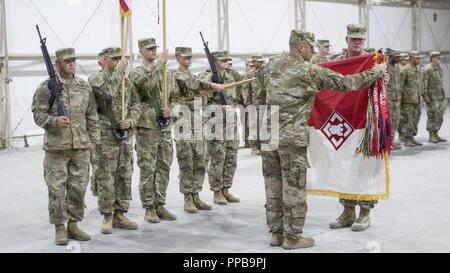 Stati Uniti Esercito Col. Patrick Sullivan, comandante del xx Engineer Brigade, E DEGLI STATI UNITI Comando Esercito Sgt. Il Mag. John Brennan, il comando sergente maggiore del XX EB, uncase loro brigata di colori a una cerimonia di premiazione che si terrà per il trasferimento delle competenze operative dall'uscita di 35th Engineer brigata per il ventesimo EB a Camp Buehring, Kuwait, Agosto 16, 2018. Il trasferimento di autorità cerimonia di premiazione si svolge a simboleggiare la conclusione di una unità della missione e l'inizio di un altro. Foto Stock