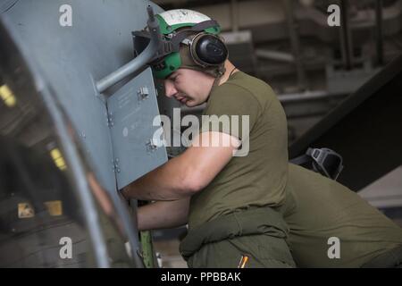 Mare di Mindanao - STATI UNITI Lancia Marine Cpl. Wyatt Stout, una cellula meccanico con un mezzo marino Tiltrotor Squadron 166 rinforzato, xiii Marine Expeditionary Unit (MEU), conduce operazioni di manutenzione su un AH-1Z Viper a bordo della San Antonio-classe di trasporto anfibio dock USS ancoraggio LPD (23) durante una regolare distribuzione programmata dell'Essex anfibio gruppo pronto (ARG) e xiii MEU, Agosto 18, 2018. L'Essex ARG/XIII MEU è un capace e letale Navy-Marine Corps team distribuiti per la 7a flotta area di operazioni a sostegno della stabilità regionale, rassicurare partner ed alleati e mantenere una postura di presenza Foto Stock