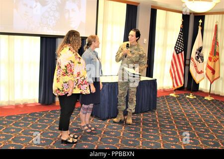 Il vice comandante di guarnigione Lt. Col. Sheila L. Coker presenta certificati di apprezzamento a Danielle Lawrence e Jill Ahrens per cantare l'inno nazionale durante l'installazione il rispetto della parità delle donne giorno di agosto 16, 2018 a Fort McCoy, Wis. Carey-Butler ha conseguito un dottorato in materia di istruzione superiore amministrazione e politica e ha lavorato nel campo dell'istruzione per più di 35 anni. Foto Stock