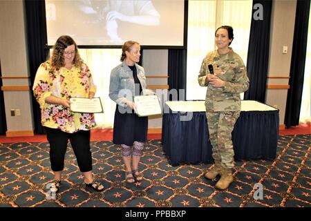 Il vice comandante di guarnigione Lt. Col. Sheila L. Coker presenta certificati di apprezzamento a Danielle Lawrence e Jill Ahrens per cantare l'inno nazionale durante l'installazione il rispetto della parità delle donne giorno di agosto 16, 2018 a Fort McCoy, Wis. Carey-Butler ha conseguito un dottorato in materia di istruzione superiore amministrazione e politica e ha lavorato nel campo dell'istruzione per più di 35 anni. Foto Stock