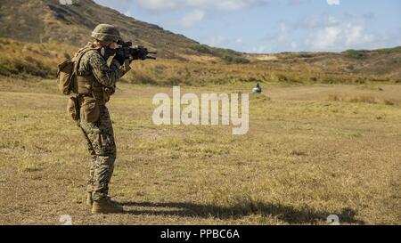 Stati Uniti Marine Corps Lance Cpl. Hugh Atkinson assegnato al chilo Azienda, 3d battaglione, 3d reggimento Marine, incendi a M27 Fanteria Fucile automatico a obiettivi sulla gamma durante l'esercizio Bougainville ho su Marine Corps base Hawaii, Kaneohe Bay, e il agosto 21, 2018. Bougainville I è la prima fase del pre-distribuzione del ciclo di formazione per il battaglione e di un esercizio focalizzata sulla creazione di piccole unità di abilità per aumentare la competenza in combattimento. Foto Stock