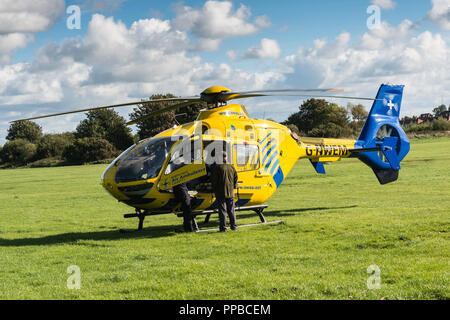 Il Nord Ovest Air Ambulance sbarcati in un campo erboso dopo la risposta a un'emergenza in Blackpool, Lancashire, Regno Unito. Foto Stock