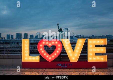 TOKYO, Giappone - 21 FEB 2018: Amore segno con luci, giapponese la statua della libertà e il Ponte di Arcobaleno al blue ora Foto Stock