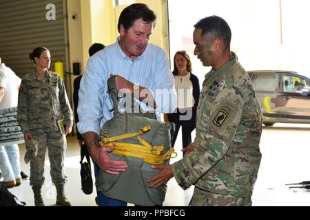 Da destra, U. S. comando esercito Sgt. Il Mag. Delfin J. Romani, assegnato per la cinquantaquattresima brigata battaglione ingegnere, 173rd Brigata Aerea, mutandine parachute funzioni PER STATI UNITI Sost. John Garamendi durante un U.S. Congressional staff visita della delegazione per il personale avviso Area di mantenimento (PAHA) presso la base aerea di Aviano, Italia, Agosto 23, 2018. Il 173rd Brigata aerea è l'U.S. Esercito di risposta di emergenza forza in Europa, in grado di proiettare le forze di pronto ovunque negli Stati Uniti Europeo, Africa Centrale o comandi in aree di responsabilità. Foto Stock