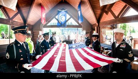 I membri di un comune di Guardia d'onore costituito da soldati, marinai, aviatori, e marines, eseguire una piegatura di bandiera cerimonia durante un memoriale di servizio ospitato da mancante in America (MIA) Progetto a Willamette Cimitero Nazionale in Happy Valley, Ore. il Agosto 29. Lo scopo della mia Progetto è quello di individuare, identificare e inter il cremato non reclamata rimane di veterani americani attraverso gli sforzi congiunti del privato, lo Stato federale e le organizzazioni. La mia Progetto ha identificato il veterano 3,959 cremains per data. Foto Stock