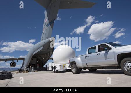 Un carrello di caricamento di un antenna a profilo ribassato su un C-17 Globemaster III durante la quarta operazioni nello spazio squadrone della mobile distribuzione presso la Base Aerea Peterson, Colorado, Agosto 27, 2018. Il processo di caricamento richiede esperti la manovra dal conducente di autocarri nonché la guida dalla 4POS aviatori al fine di garantire la maggior risorsa è caricato correttamente. Foto Stock