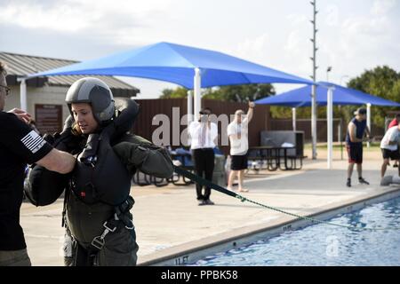 Airman 1. Classe Giordania Turnbaugh, ottantaduesima medicina aerospaziale aerospaziale squadrone tecnico di fisiologia, fissa il suo cablaggio durante l'acqua sopravvivenza corso di aggiornamento a Sheppard Air Force Base in Texas, Agosto 17, 2018. Turnbaugh è la simulazione viene trascinata attraverso l'acqua dal suo scivolo e deve rilasciare il suo cablaggio o sono a rischio di annegamento. Foto Stock