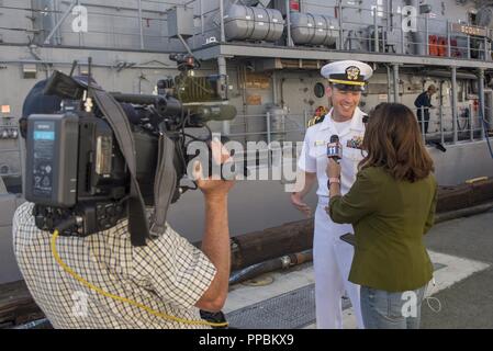 LOS ANGELES (30 agosto 2018) Lt. La Cmdr. Shawn Callihan, il delegato a bordo il Vendicatore di classe contromisure mine nave USS Scout (MCM 8), discute Los Angeles Settimana della flotta (LAFW) con Gina Silva, un reporter di Fox News 11, durante un'intervista. LAFW è una opportunità per il pubblico americano e per soddisfare la loro Marina Militare, Marine Corps e Guardia Costiera team e l'esperienza dell'America servizi di mare. Durante la settimana della flotta, servizio i membri partecipano a vari eventi a servizio della comunità, capacità di presentazione e di attrezzature per la comunità e godetevi l'ospitalità di Los Angeles e nelle aree circostanti Foto Stock