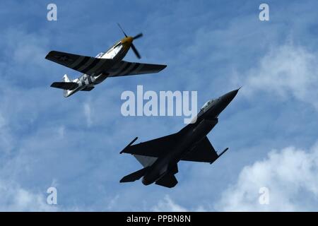 Un F-16 Fighting Falcon, destra e P Mustang volare in formazione durante un volo di patrimonio a Cleveland, Ohio, Sett. 1, 2018. Il volo si è verificato come parte del Cleveland National Air Show all'Aeroporto Burke Lakefront e onorato il passato e il presente servizio soci. Foto Stock