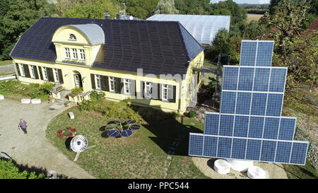 14 settembre 2018, Meclemburgo-Pomerania, Luebow: l'associazione area dell'iniziativa solare meclemburgopomerania occidentale con la vecchia casa padronale e da una vela di sun. Tutto il guscio esterno del vecchio edificio serve come fonte di energia e di storage. Dietro la casa padronale si erge una serra del futuro in vetro speciale. L'iniziativa solare Mecklenburg Vorpommern celebra il suo quindicesimo anniversario in questi giorni. (Foto aeree con un drone /opter) (a dpa 'Solarinitiative MV: Ananas e le banane sono mature' dal 25.09.2018) Foto: Bernd Wüstneck/dpa-Zentralbild/dpa Foto Stock