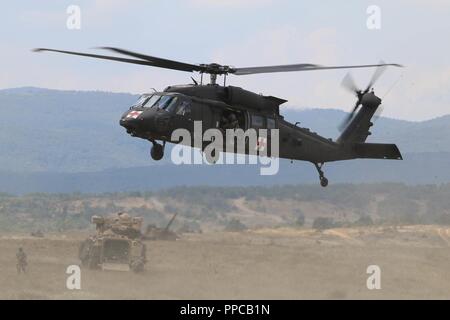 Un U.S. Esercito UH-60 Black Hawk elicottero si prepara a terra durante una evacuazione medica (MEDEVAC) trapano per un figurativamente-soldato ferito durante una tabella XII Live esercitazione antincendio, Novo Selo Area Formazione, Bulgaria, 23 agosto 2018. Questo esercizio è a sostegno di Atlantic risolvere, il permanere di un esercizio di formazione tra la NATO e gli Stati Uniti Le forze. Foto Stock