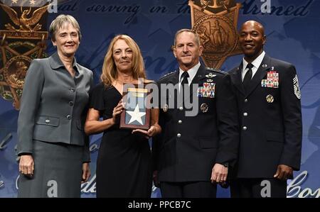 Segretario della Air Force Heather Wilson, Air Force capo del personale di David L. Goldfein e Capo Comandante Sergente della Air Force Kaleth O. Wright presente la medaglia di Honor flag per Valerie Nessel, coniuge di Medal of Honor destinatario Tech. Sgt. John Chapman durante la Hall of Heroes cerimonia di induzione al Pentagono, in Arlington, Virginia, Agosto 23, 2018. Il sergente Chapman postumo è stato premiato con la medaglia d'Onore per azioni su Takur Ghar montagna in Afghanistan il 4 marzo 2002. Un elite Special Operations team è stato assalito dal nemico e passò sotto il fuoco pesante da più direzioni. Chapman Foto Stock