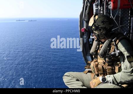 Oceano atlantico (Agosto 30, 2018) capo (seleziona) Aircrewman navale (elicottero) Joel James, assegnato al 'Dragon cacciatrici' di elicottero di mare squadrone di combattimento (HSC) 11, osserva da un MH-60S Seahawk elicottero come navi assegnate al di Harry Truman Carrier Strike gruppo e l'Abraham Lincoln Carrier Strike gruppo il transito sul mare in formazione durante la conduzione di dual-carrier supporto operazioni. In aggiunta alla dimostrazione della Marina inerenti la flessibilità e la scalabilità di questa evoluzione fornisce la possibilità di condurre complesse e multi-unità di formazione per migliorare la marittima e di interoperabilità COM Foto Stock