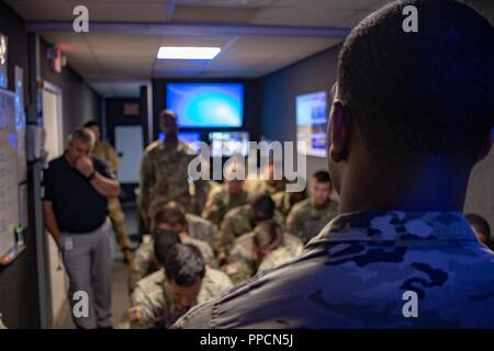 Delta Forward Support Company, 6° Stormo, 8° reggimento di cavalleria, 2° Brigata corazzate contro il personale del team Sgt. Antonio Brown conduce un dopo-azione di revisione presso il gioco Virtuale Suite di formazione a Fort Stewart, Ga., 30 agosto. L'unità utilizza la suite del convoglio simulata la formazione per preparare per la distribuzione per il Centro Nazionale di Allenamento il prossimo anno. Foto Stock