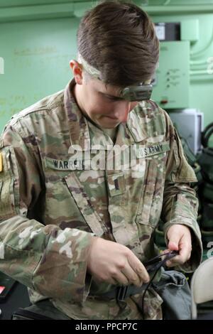 1Lt. Garrett Warren, il funzionario responsabile del controllo e del comando e le operazioni correnti per la sede centrale e sede società, truppe speciali battaglione, terza divisione di fanteria supporto brigata, avvolge una corda durante il posto di comando esercizio II su Ft. Stewart, Ga. Agosto 30. Warren era aiutare la sua sezione abbattere non-attrezzatura essenziale che la notte in modo da spostare la posizione di esercizio la mattina successiva. Foto Stock