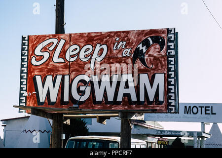 Segno per la famosa Route 66 punto di riferimento - il Motel Wigwam invita gli ospiti a dormire in una concreta struttura wigwam. Foto Stock