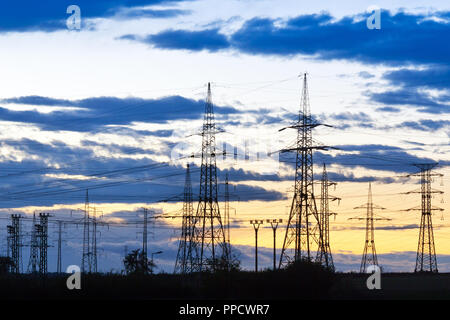 Energia elettrica - potenza industria energetica - poli elettrici al tramonto con coloful sky Foto Stock