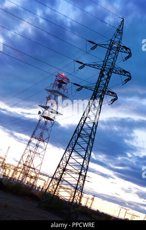 Energia elettrica - potenza industria energetica - poli elettrici al tramonto con coloful sky Foto Stock