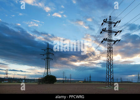 Energia elettrica - potenza industria energetica - poli elettrici al tramonto con coloful sky Foto Stock