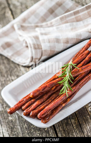 Bastoncini di salsiccia snack. Il chorizo snack sulla piastra. Foto Stock