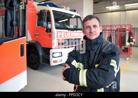 Ritratto di un vigile del fuoco nel centro di operazioni al veicolo antincendio Foto Stock