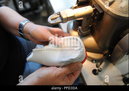 Produzione di "diamond Brand' scarpe casual del marchio Bruetting in Schwarzenbach an der Saale. 50 collaboratori producono 400 paia di scarpe a mano per i vari client. In questo processo la calzatura viene messo su un ultimo. In questa fase la calzatura è 'gestrobelt' (cucite in calza, processo chiamato dopo una macchina che esiste solo in corrispondenza Bruetting. Foto Stock