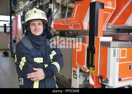 Ritratto di un vigile del fuoco nel centro di operazioni al veicolo antincendio Foto Stock