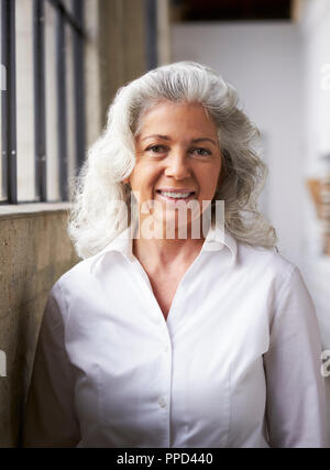 Senior imprenditrice bianco in maglia bianca, verticale Foto Stock